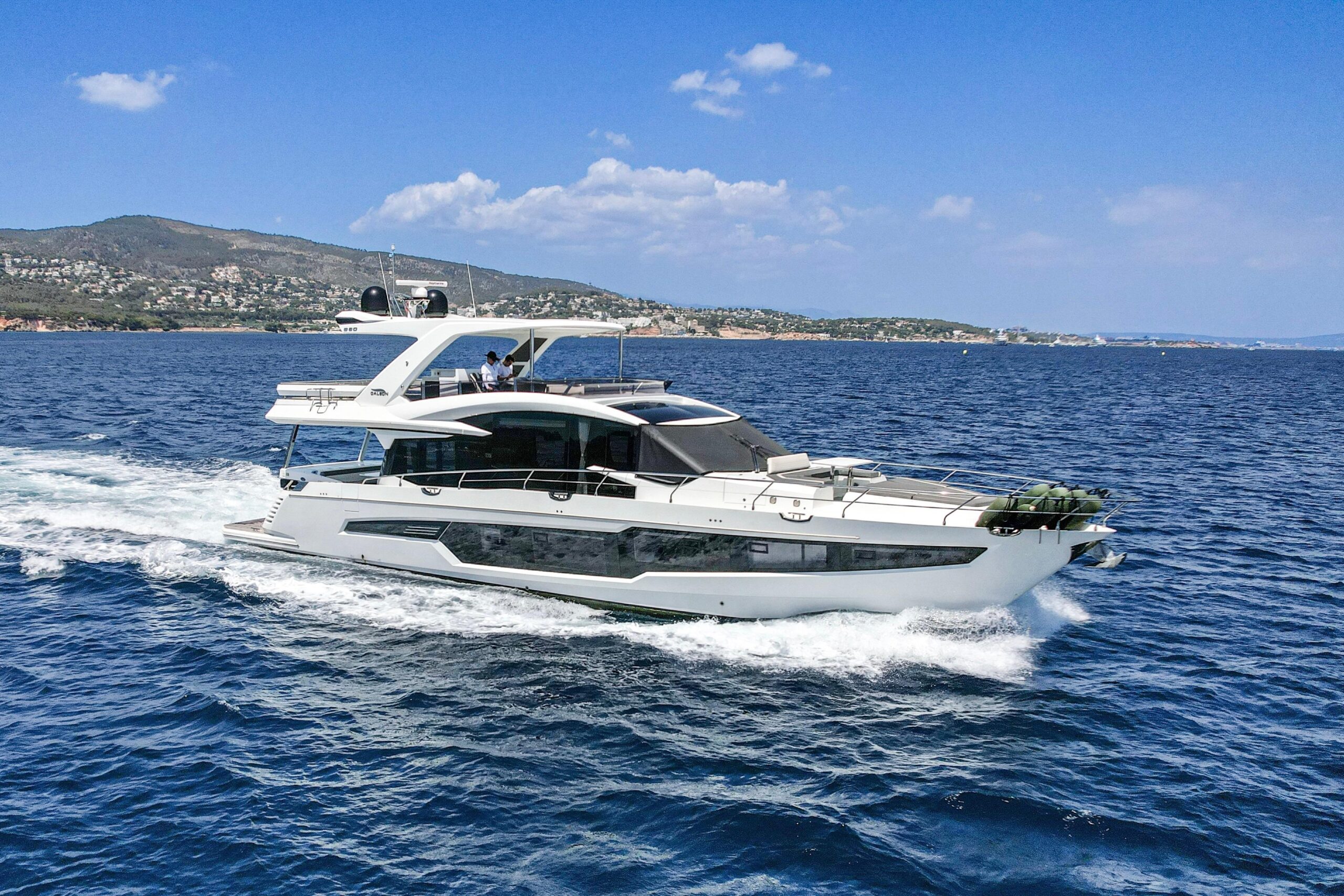25m Galeon 800 Fly power yacht by Tony Castro Yachts cruising at sunset with sleek modern profile and illuminated superstructure reflected on calm water