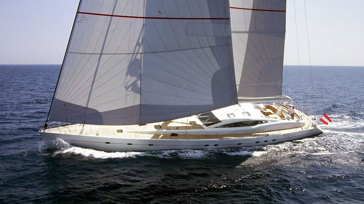 32m Red Sula sail custom yacht by Tony Castro Yachts with white hull and teak deck, heeling under large mainsail on deep blue open sea