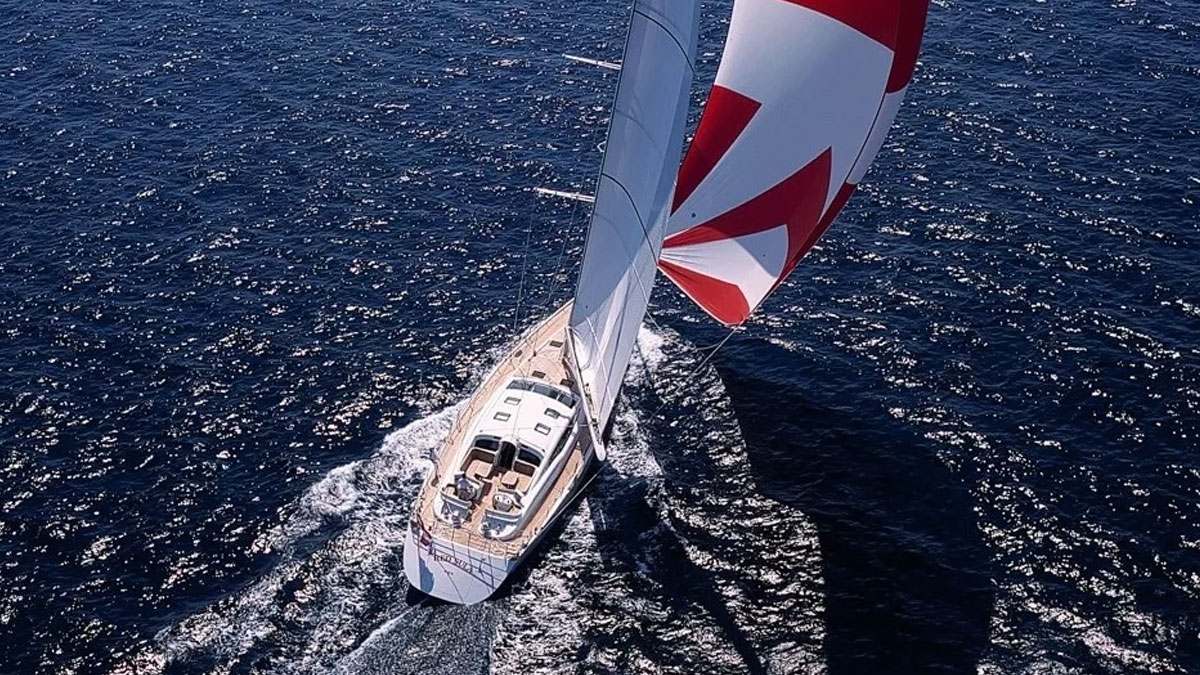 32m Red Sula sail custom yacht by Tony Castro Yachts with white hull and teak deck, heeling under large mainsail on deep blue open sea