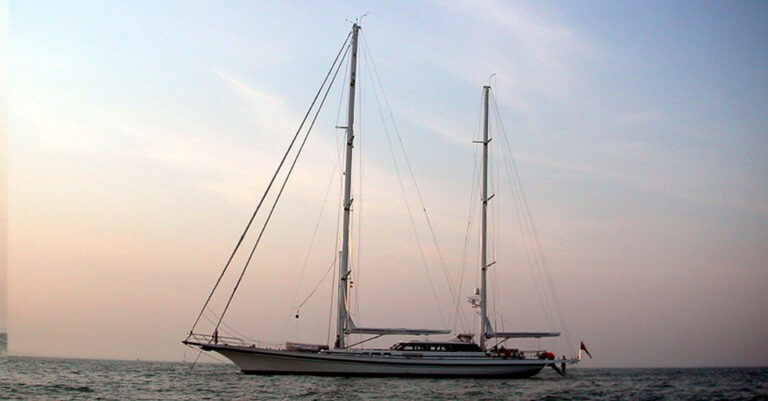 42m Jongert Islandia sail custom yacht by Tony Castro Yachts with white hull and twin masts, anchored peacefully at dusk on calm water