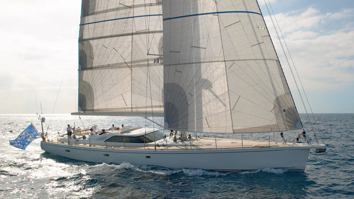 25m CNB Simeron sail custom yacht by Tony Castro Yachts with white hull and crew on deck, sailing under full canvas with European flag flying on sparkling open sea