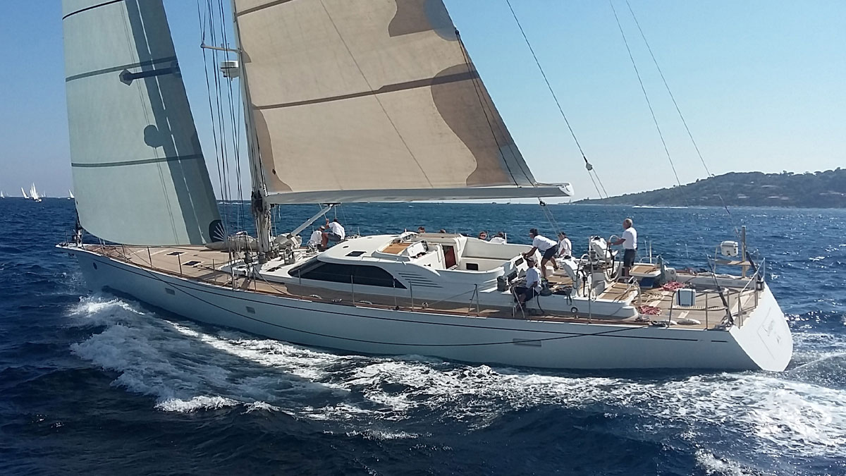 25m CNB Simeron sail custom yacht by Tony Castro Yachts with white hull and crew on deck, sailing under full canvas with European flag flying on sparkling open sea