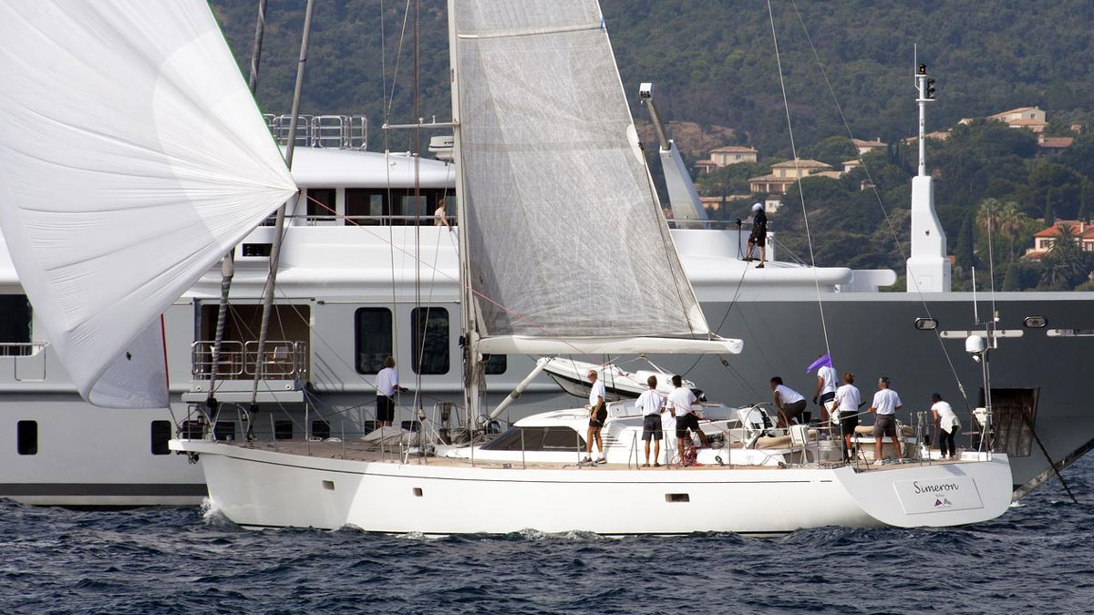 25m CNB Simeron sail custom yacht by Tony Castro Yachts with white hull and crew on deck, sailing under full canvas with European flag flying on sparkling open sea