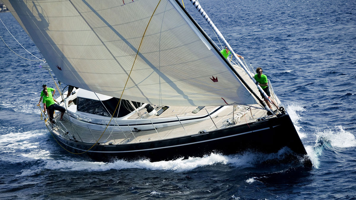 29m Jongert Scorpione Dei Mari sail custom yacht by Tony Castro Yachts with dark navy hull and crew on deck, racing under full sail on open blue sea