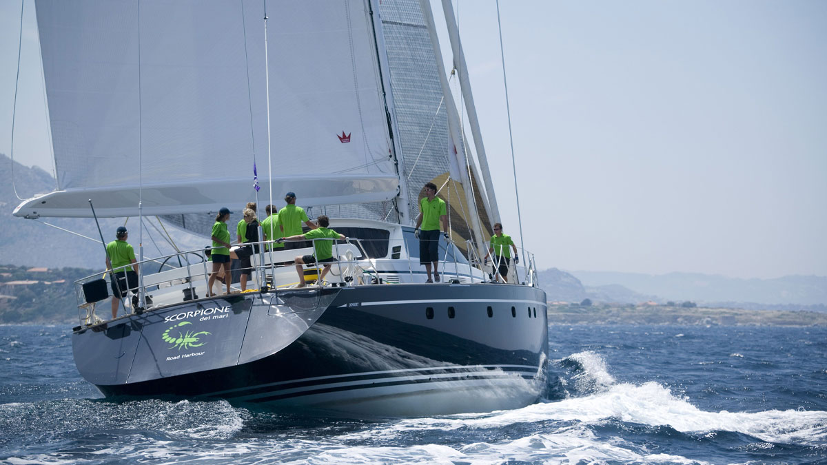 29m Jongert Scorpione Dei Mari sail custom yacht by Tony Castro Yachts with dark navy hull and crew on deck, racing under full sail on open blue sea