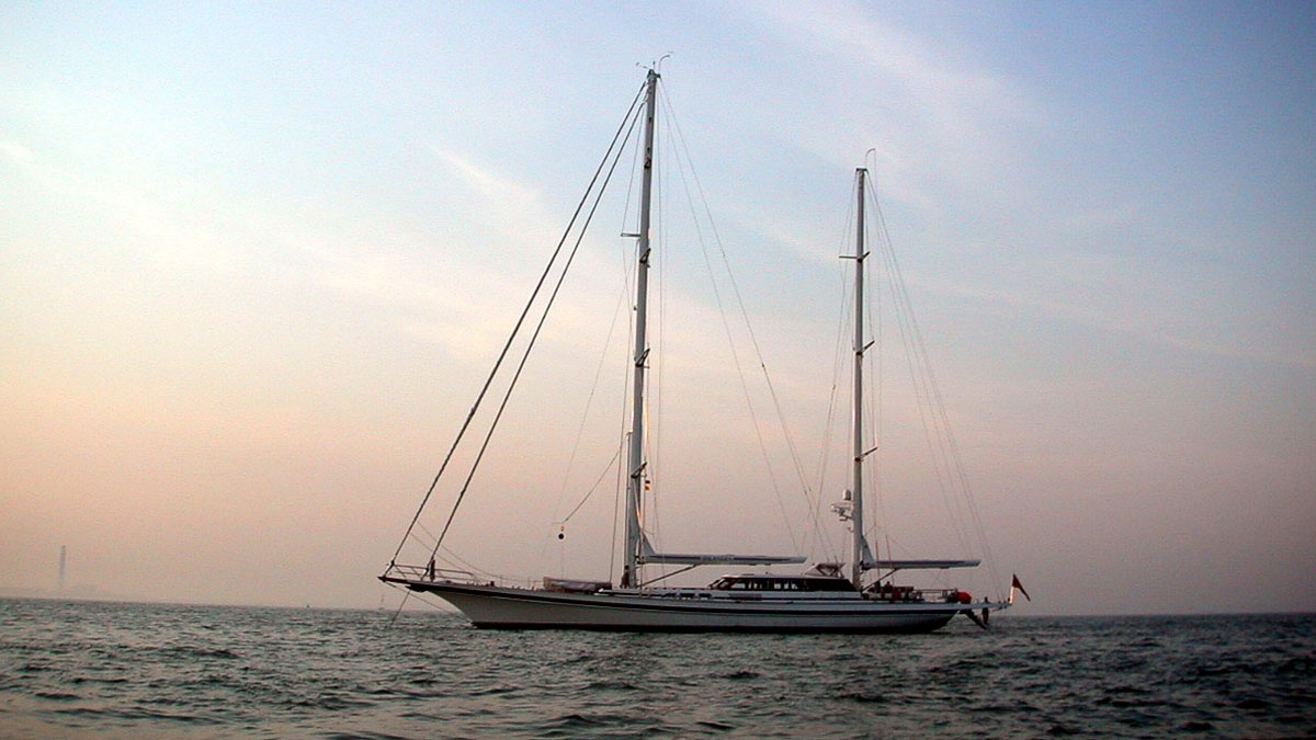 42m Jongert Islandia sail custom yacht by Tony Castro Yachts with white hull and twin masts, anchored peacefully at dusk on calm water