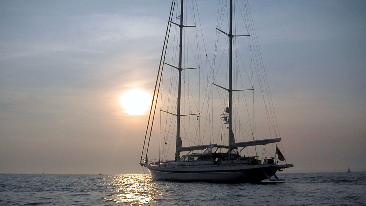 42m Jongert Islandia sail custom yacht by Tony Castro Yachts with white hull and twin masts, anchored peacefully at dusk on calm water